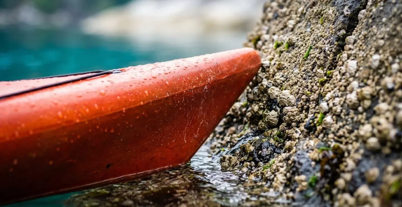 Vue macro détaillée de la proue d'un kayak s'approchant d'une crique rocheuse
