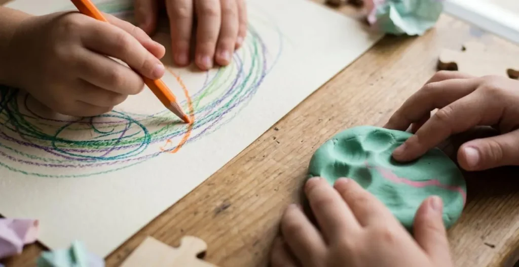 Enfants pratiquant des activités créatives calmes dans une pièce ombragée pendant la sieste